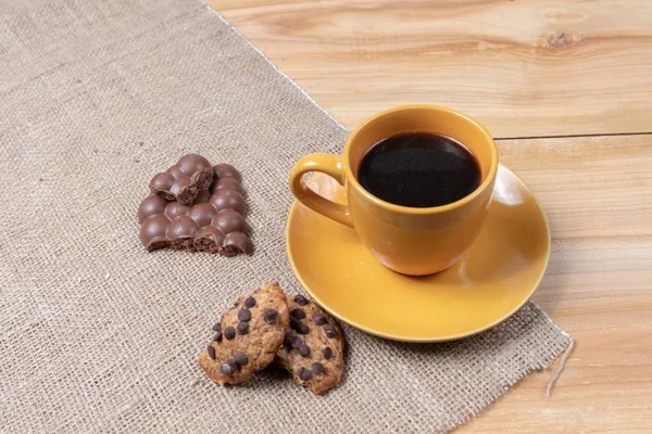 Ev yapımı kurabiyeli bir fincan kahve ahşap arka planda çikolatalı tatlılar günün başlangıcında aromatik aromalar.
