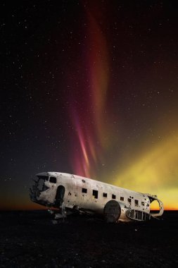 Terk edilmiş Dc-3 uçak aurora arka plan ile. İzlanda'nın en popüler landmark.