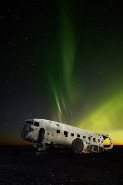 Terk edilmiş Dc-3 uçak aurora arka plan ile. İzlanda'nın en popüler landmark.