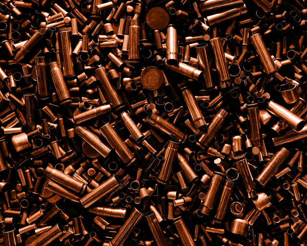 Different size bullet shells on the black ground. War concept.