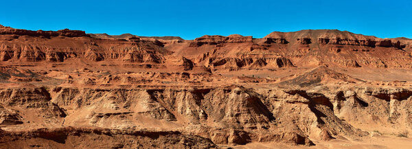 Herman Cav Canyon at sunset. South Gobi, Mongolia. Herman Tsav Canyon. Red Sandstone plateau, Martian landscape. The site of many paleontological finds. Cemetery of dinosaurs.