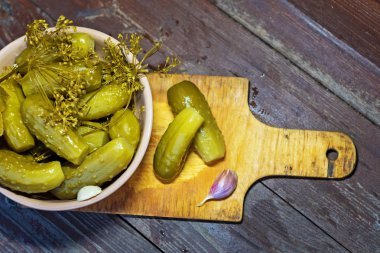 Otlar ve baharatlar ile ev yapımı salatalık turşusu. Ahşap bir arka plan üzerinde.