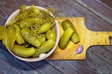 Otlar ve baharatlar ile ev yapımı salatalık turşusu. Ahşap bir arka plan üzerinde.