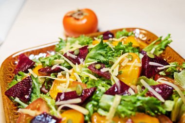 Sağlıklı salata marul salatası, Trabzon hurması ve pancar. Trabzon hurması salata. Diyet. Vejetaryen yiyecekler.