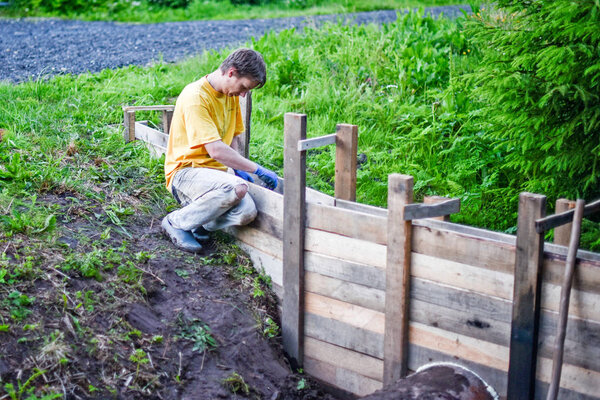 Laying formwork, concrete beams for the construction of the fence.
