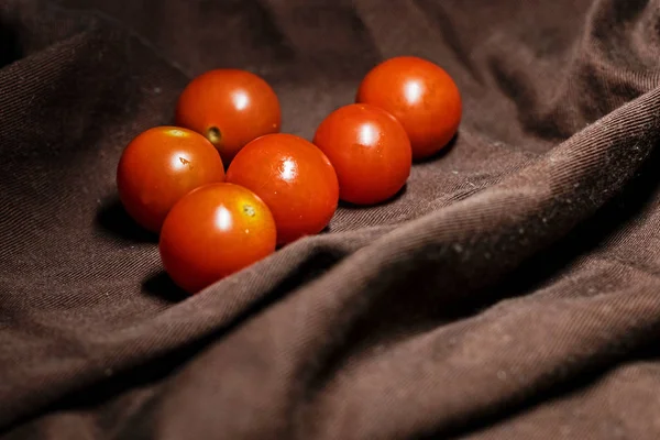 fresh cherry tomatoes on a brown towel. ingredients for the salad. view from the top.