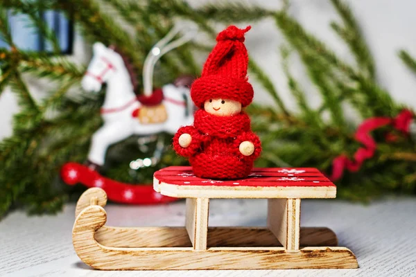クリスマス カード クリスマス ツリーとおもちゃの馬の背景にサンタのそりにニットウェアの明るい赤いおもちゃの子供 クリスマス ライト — ストック写真