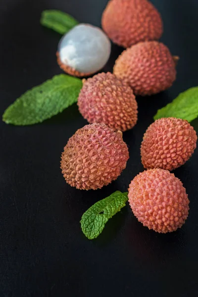 Siyah arka planda taze organik liçi meyvesi.