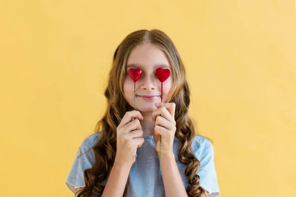 年轻的女孩模型与瓦伦丁的心在她的手中 爱的概念 情人节礼物 在黄色背景 — 图库照片