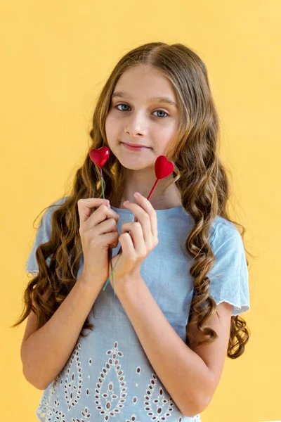 美丽的年轻女孩 手里拿着两颗心 情人节的概念 黄色背景 — 图库照片
