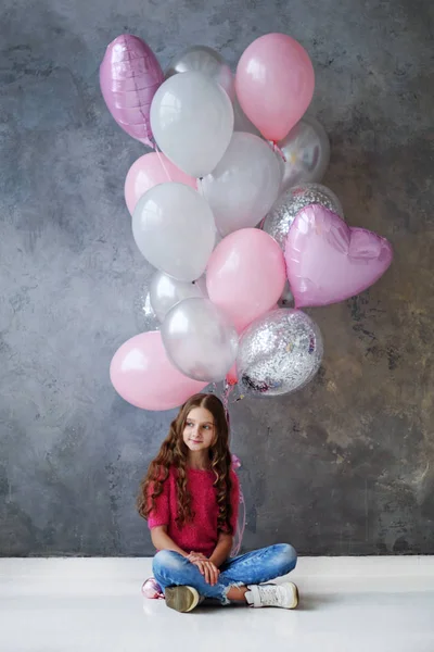 バレンタインは グレーの背景にピンク グレーの風船を持つ美少女です 美しい幸せな女の子 うれしそうなモデルのポーズ バレンタインの日を祝う — ストック写真