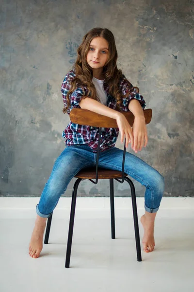 十几岁的女孩在椅子上玩 在灰色背景上 模型测试 — 图库照片