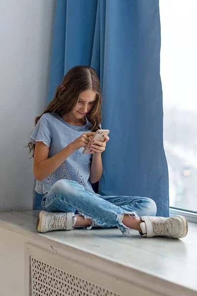 Retrato Uma Adolescente Caucasiana Sentada Perto Janela Com Telefone Celular — Fotografia de Stock