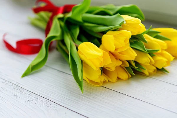 Buquê de flores de tulipas amarelas em fundo de madeira branca. À espera da Primavera. Feliz cartão de Páscoa, dia da mãe, 8 de Março. Posição plana, vista superior . — Fotografia de Stock