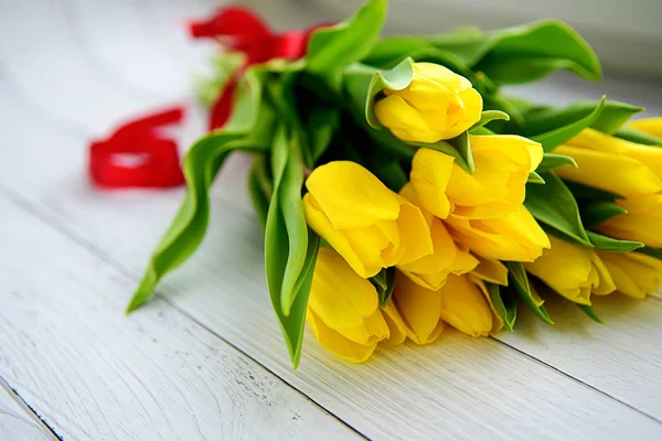 Bouquet of yellow tulips flowers on white wooden background. Waiting for spring. Happy Easter card, mother's day, March 8. Flat position, top view. Royalty Free Stock Photos