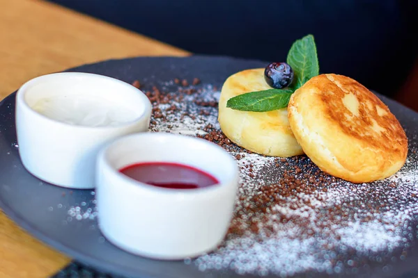 Panquecas de queijo cottage com mirtilo e hortelã para café da manhã ou almoço. Engarrafamento e nata azeda . — Fotografia de Stock