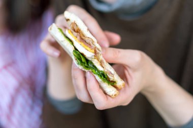 Kızın elini tutarak taze, lezzetli sandviç.