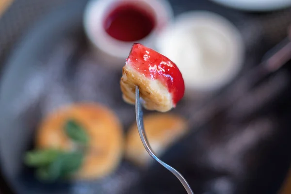 Leckeres Stück Käsekuchen mit Marmelade auf einer Gabel — Stockfoto