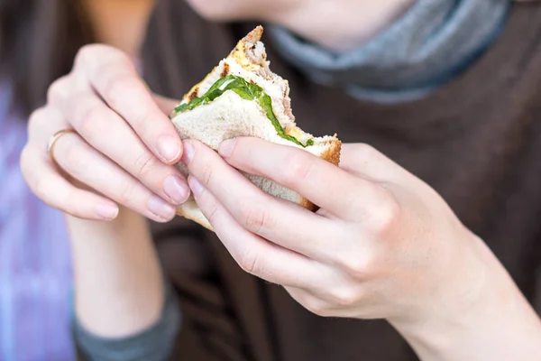 Mão de menina segurando um delicioso sanduíche de clube fresco . — Fotografia de Stock