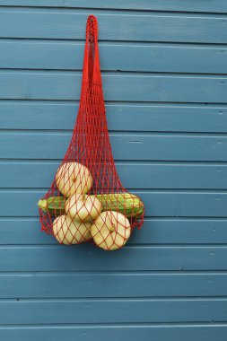 Mavi arka planda taze Pattison sebzeleri. Mavi arka planda çevre dostu ağ torbası. Organik sebze hasadı kavramı.