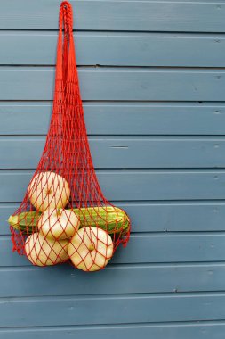 Mavi arka planda taze Pattison sebzeleri. Mavi arka planda çevre dostu ağ torbası. Organik sebze hasadı kavramı.