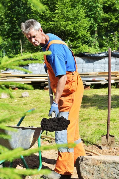 男農家はプライベートガーデンでシャベルで土を掘る 労働者は農場で黒い泥を緩め 農業秋の詳細の概念 シャベルを持った男が掘る準備をしている — ストック写真