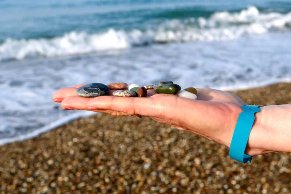 Zbliżenie Kobiet Ręce Gospodarstwa Kolorowe Skały Plaży Zamazanym Tle Plaży — Zdjęcie stockowe