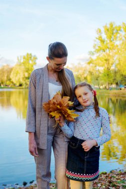 Mutlu anne ve kız Sonbahar Parkı 'nda eğleniyorlar.