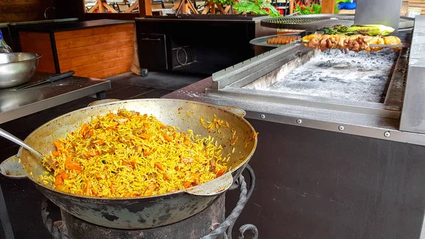 Saboroso pilaf uzbeque em um caldeirão ao ar livre no festival de comida de rua — Fotografia de Stock