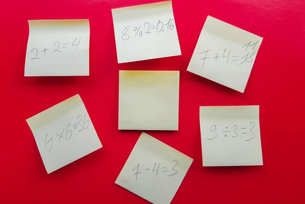 Notes jaunes autocollantes vierges avec des équations mathématiques et de les résoudre sur un fond rouge, concept d'affaires et de travail d'étude. Autocollants commémoratifs jaunes sur le mur rouge. Mise en page — Photo