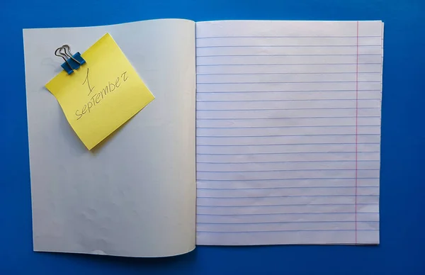 Cuaderno abierto en un forro blanco sobre una mesa de madera azul — Foto de Stock