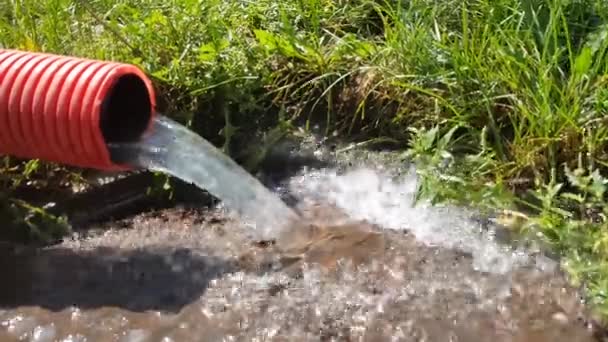 배수구 아래로 흐르는 오렌지 플라스틱 시스템 폐수에 비디오 슬로우 스플래시 — 비디오