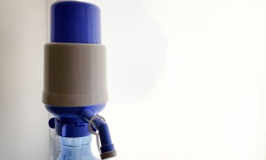 bir su şişesi üzerinde pompa. Beyaz arka planda yakın çekim