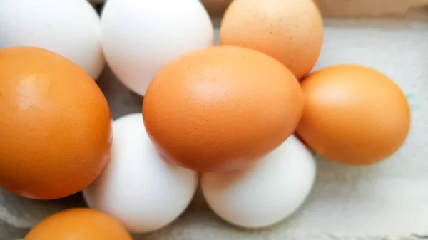 Mnoho bílých a hnědých vajec je náhodně položvybráno — Stock fotografie