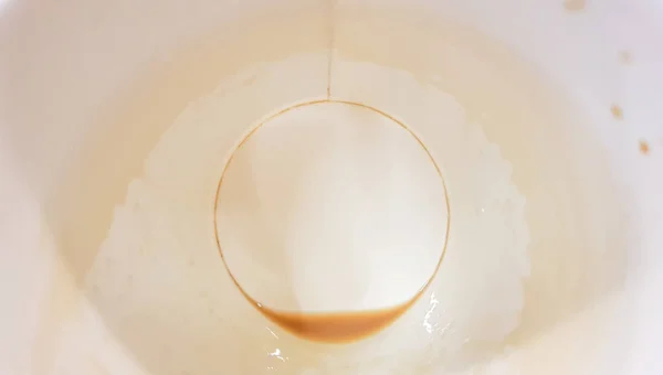 Sobras de comida en un plato de papel y vacío taza de café de papel sucio en una mesa de madera en un café de comida rápida — Foto de Stock