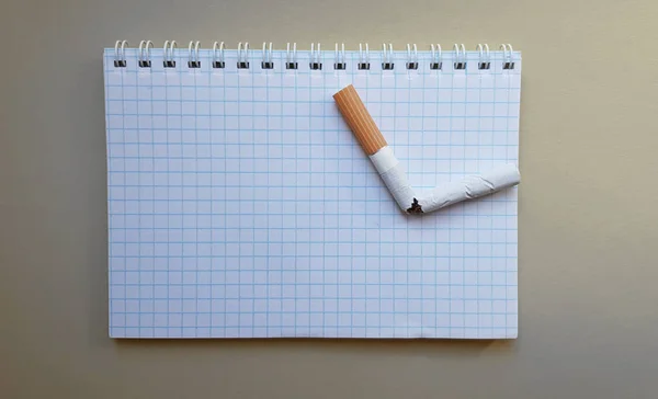 Světový den bez tabáku, den kouření. Rozbitá cigareta v obchodním poznámkovém bloku, místo pro text — Stock fotografie