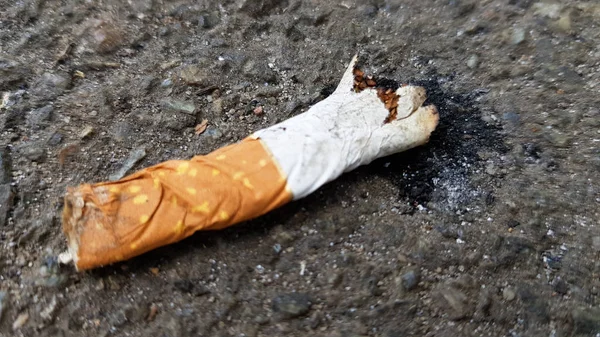 Uzavřete poškozený cigaretový zadek na asfaltu s prostorem pro kopírování. Mezinárodní den bez tabáku. Světový den proti cigaretám, nikotinu a tabáku — Stock fotografie