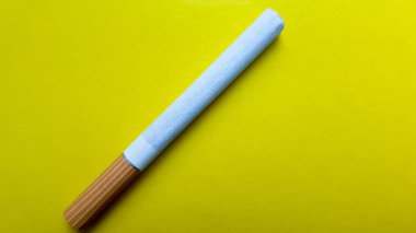 Sigara sarı bir arka plan üzerinde çapraz izole