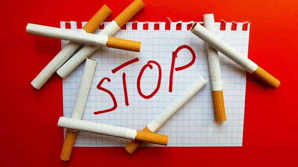 Ein Aufkleber mit der Aufschrift "Stop" steckt in einer Zigarettenschachtel. Welt kein Tabaktag. Rauchen aufhören. Kampf mit Zigaretten — Stockfoto