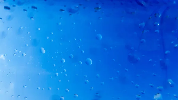 Muchas gotas de agua dentro de una botella de plástico. Fondo azul con gotas de agua —  Fotos de Stock