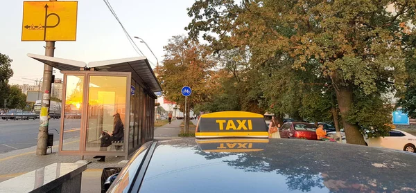 Light Box Checker Taxi jasnożółty na dachu samochodu na tle nieba, miasta i ludzi — Zdjęcie stockowe