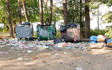 Ukrayna, Kiev - 11 Eylül 2019: Eski paslı metal çöp konteynerleri plastik atık ve dağınık çöp dolu, bir şehir parkı veya ormanda ayakta. Çevre kirliliği