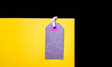 Boş kahverengi karton fiyat etiketi veya etiket sarı arka plan üzerinde. üst görünüm