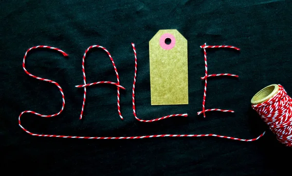 黒い背景にスプールを持つ赤い糸で作られた販売、割引ワード。背景、休日の概念。ブラックフライデー - ショッピング、プロモーション、割引、販売の国際デー。販売シーズンは、 — ストック写真
