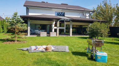 Ukrayna, Kiev - 24 Eylül 2019: Yeni bir modern Avustralya tarzı ev cephe. Yeşil bir çim üzerinde büyük bir evin avlusında bir barbekü ile piknik. Lüks Villa Resort İç Mekan