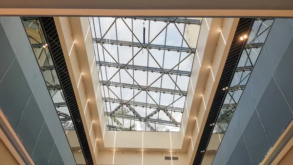 Strukturverglasung der Fassade. abstrakter Hintergrund mit gläsernen Deckenelementen in einem modernen Gebäude. Blick in den blauen Himmel durch ein Glasfenster, getrennt durch Gitterelemente. — Stockfoto