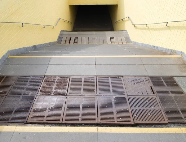 Leerer gelber unterirdischer Fußgängerüberweg. Tunnel und Tageslicht am Ende. Schritte nach oben am Zebrastreifen. ein langer Betontunnel mit Laternen im Untergrund der Stadt. — Stockfoto