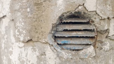 beton havalandırma deliği. Metal endüstriyel yuvarlak havalandırma kapağı. Yatay metal çizgili paslı ve kirli eski yuvarlak havalandırma çerçevesi.