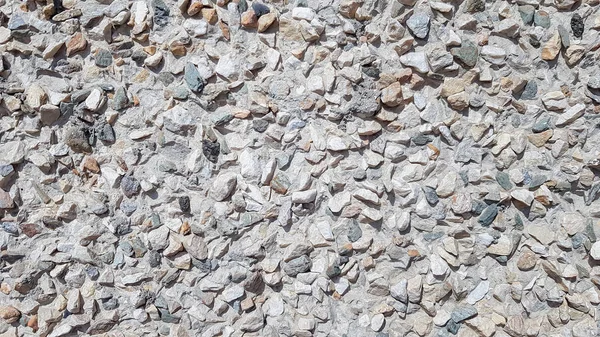 Pebbles Rubble In the cement courtyard. Dirty cracked old grunge vintage light gray concrete and cement mold texture wall or floor background with weathered paint and scratches