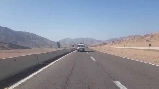 Egito, Sharm El Sheikh - 20 de junho de 2019: Passeio de caminhão de coleta pelo deserto do Egito. A caminho do deserto. A estrada entre as rochas, o carro monta em uma estrada de asfalto lisa. Terras altas e — Vídeo de Stock